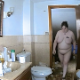 A hidden camera records a fat, butch-looking woman with tattoos taking a piss and a shit while sitting on a toilet and then wiping her ass. A plop is heard over her pissing. About a minute.